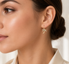 Close-up of a woman wearing a gold earring with a leaf design.